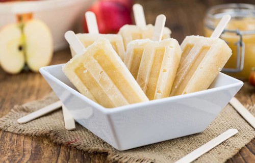 Apple Popsicles on an old wooden table (close-up shot, selective focus)