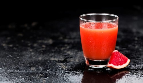 Portion of freshly squeezed Grapefruit Juice on a vintage background (selective focus, close-up