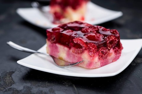 Fresh made portion of Raspberry Cake (selective focus, close-up shot) on rustic background