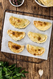 Portion of healthy Empanadas on an old wooden table (selective focus, close-up shot)