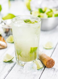 Fresh made Caipirinha with ingredients in the background