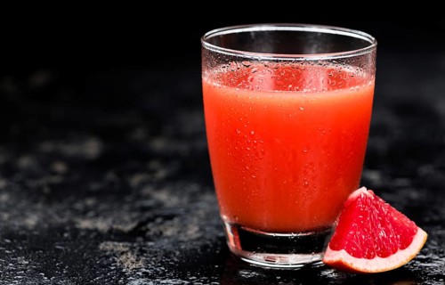 Slate slab with freshly squeezed Grapefruit Juice (selective focus, close-up shot)