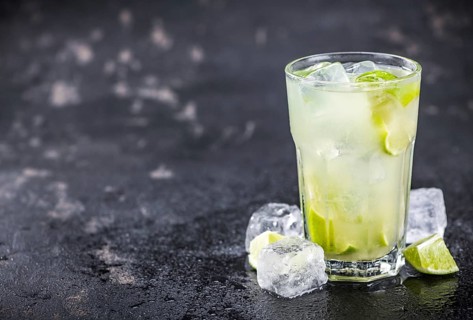 Fresh made Caipirinha with ingredients in the background