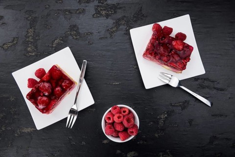 Fresh made Raspberry Cake on a rustic slate slab (close-up shot, selective focus)
