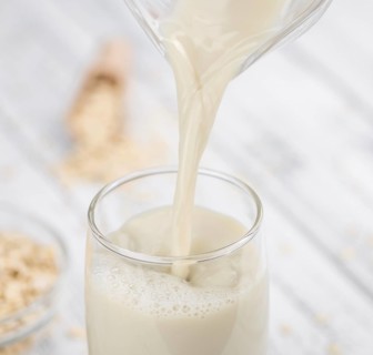 Wooden table with Oat Milk (detailed close-up shot, selective focus)