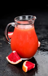 Portion of freshly squeezed Grapefruit Juice on a vintage background (selective focus, close-up