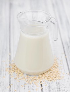 Wooden table with Oat Milk (detailed close-up shot, selective focus)