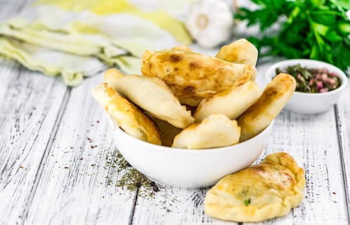 Portion of healthy Empanadas on an old wooden table (selective focus, close-up shot)