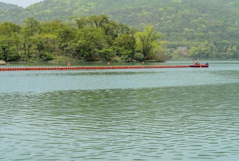 A calm lake with green hills and a boat in the background, in Suncheon, South Korea, Asia