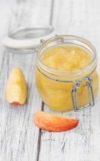 Homemade Applesauce (selective focus, close-up shot) on vintage background with some fresh fruits