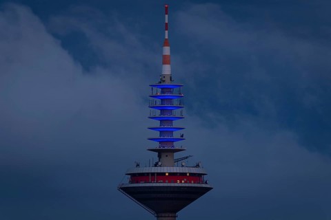 The top of the Europe Tower in Frankfurt am Main shines in the blue of the European Union (EU)