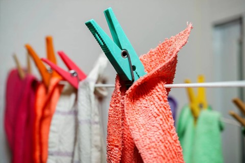 Different colored kitchen towels on a clothesline drying
