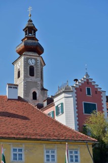 Close-up of a church tower and neighbouring historic buildings under a clear blue sky, St.