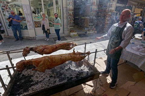 Man grilling lambs on a spit in front of a taverna, Easter lamb, Plaka neighbourhood, Athens,