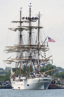 New London, Connecticut, USA, July 2012: Crew members high up in the rigging furl the sails on the