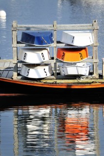 Six colorful blue, orange and white wooden dinghy sailboats stored for the evening, Rockland Maine