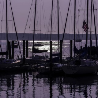 Sailboats in silhouette at anchor with a purple sunrise. Niantic, East Lyme, Connecticut, New