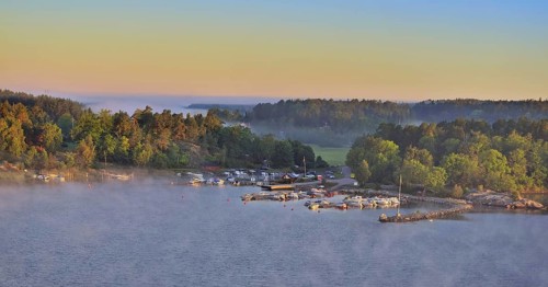 Sweeping panoramic view of boats moored amid the islands of the Stockholm Archipelago at dawn on a