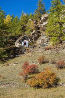 A small chapel nestled in an autumnal, rocky landscape with trees, Saas Fee, Switzerland, Europe