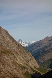 A narrow mountain gorge with snow-capped peaks in the background, Saas Fee, Switzerland, Europe