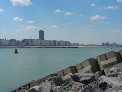 City on the coast with skyscrapers and breakwaters along the sea under a cloudy sky, oostende,