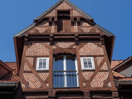Close-up of a historic half-timbered house with striking wooden structure, balconies and red roof