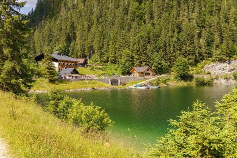 A small lake with surrounding houses and forest, nestled in a peaceful and relaxing mountain