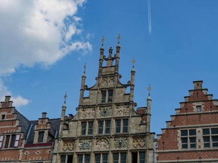 Close-up of richly decorated gables of an old building with a clear sky in the background, Ghent,