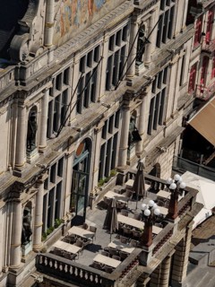Large balcony of a historic building with chairs, tables and statues, Ghent, Belgium, Europe