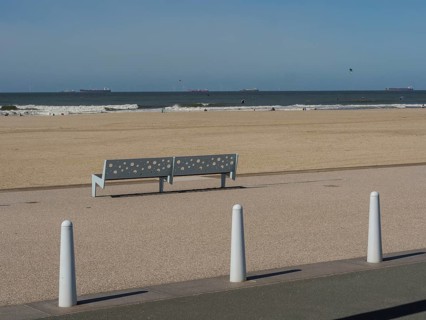 Empty bench on the footpath along the beach, sea and ships on the horizon, scheveningen, the