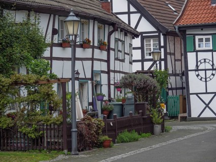 Cosy street with half-timbered houses, flowers and street lamps in a traditional village,