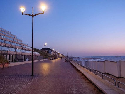 Dusk on a quiet beach promenade with glowing lanterns, de haan, Belgium, Europe