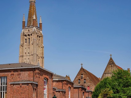 Historic church with high stone towers, framed by a clear summer sky, Bruges, Belgium, Europe