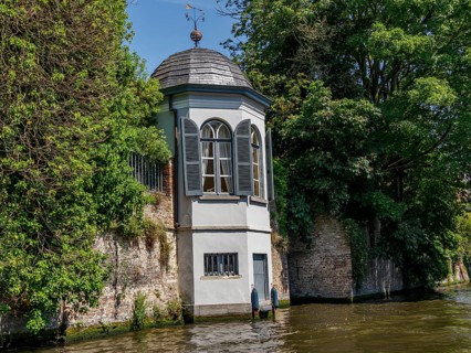 Pavilion by the river, surrounded by trees and a brick wall, peaceful atmosphere, Bruges, Belgium,