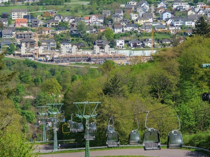 Cable car over a cityscape with hills and green trees under a blue sky, Saarburg, Germany, Europe