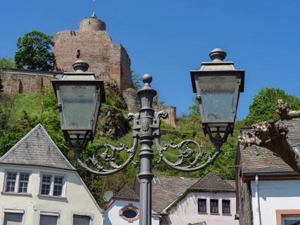 Two street lamps in front of a castle and other historical buildings in the village, Saarburg,