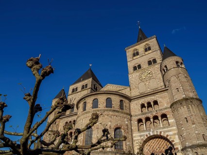 Stone church with several towers under a deep blue sky, Trier, Germany, Europe
