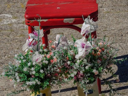 A flower arrangement with orchids in front of a rustic red bench on sandy ground, langeoog, germany