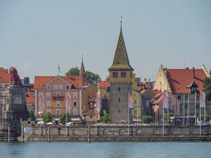 Historic buildings and a city tower with flags at the harbour, Lindau, Lake Constance, Germany,