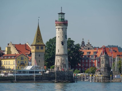 Lighthouse and historic buildings on the lakeshore in a town, Lindau, Lake Constance, Germany,