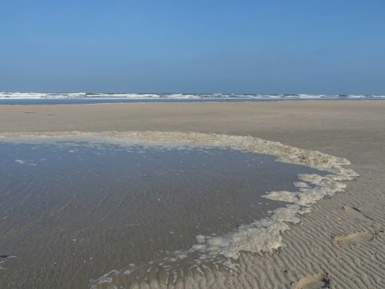 A wide, sandy shore with water accumulations and the sea in the background, juist, east frisia,
