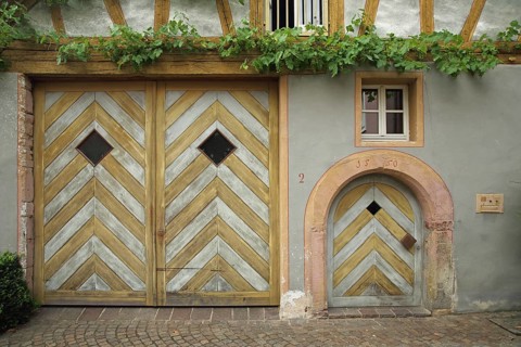 Yellow Tor tor and front door on half-timbered house built in 1550 with date and grapevine,