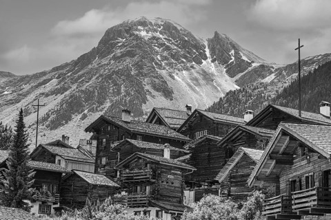 Nested old wooden houses, in the background the summit of the mountain Scex de Marenda, historic