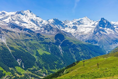 Alpine meadows at the summit of Corne de Sorebois, with the snow-covered peaks of Weisshorn,