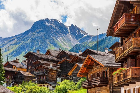 Nested old wooden houses, behind the summit of the Scex de Marenda mountain, historic village