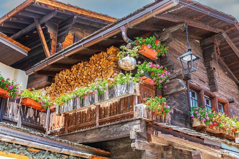 Nested old wooden house with lantern on the roof and flower boxes in front of windows and