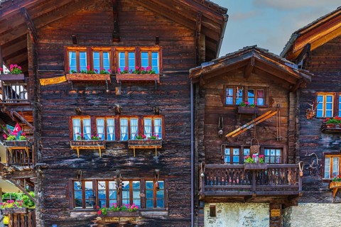 Old wooden houses with flower boxes in front of windows and balconies, historic village centre,