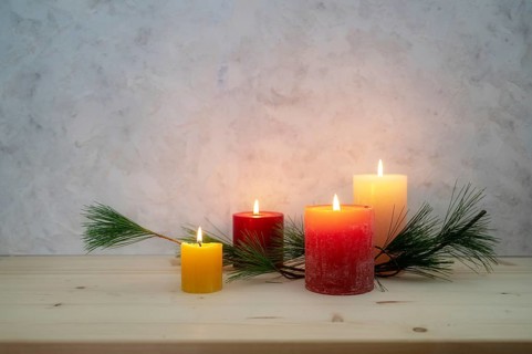 Four candles lit for the fourth Advent, pine branch as a simple, minimal decoration on a light