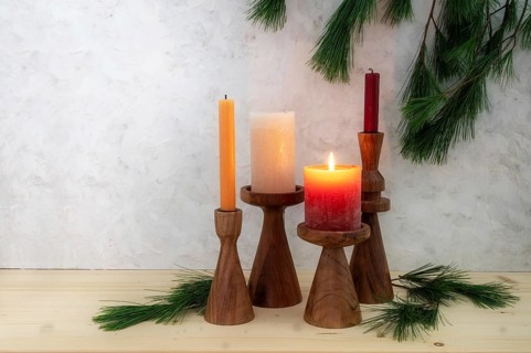 Four candles on wooden stands, one is lit for the first Advent, pine branch decoration, light