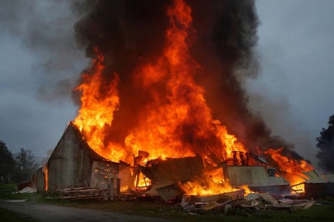 Flames and smoke rise from burning farm building